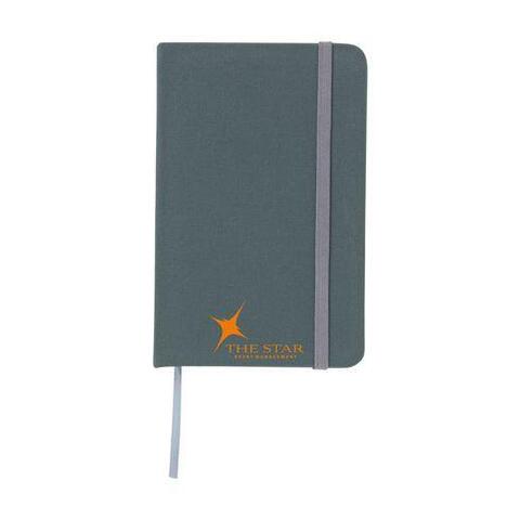 Grå notesbog i A6-format med hårdt cover af bomuld, 80 siders cremefarvet og linjeret papir, elastiklukning, bundet ryg, trykt logo og silkebånd.