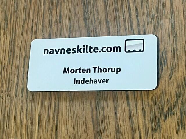 Navneskilt i hvid plast 70x30 mm med nål eller magnet - navn & titel samt logo