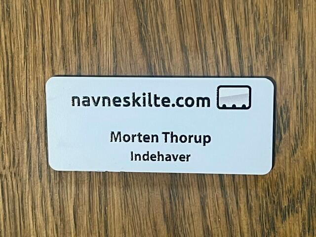 Navneskilt i hvid plast 70x30 mm med nål eller magnet - navn & titel samt logo