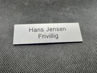 Navneskilt i plast sølv/sort med navn og titel - 80x25 mm - med tape